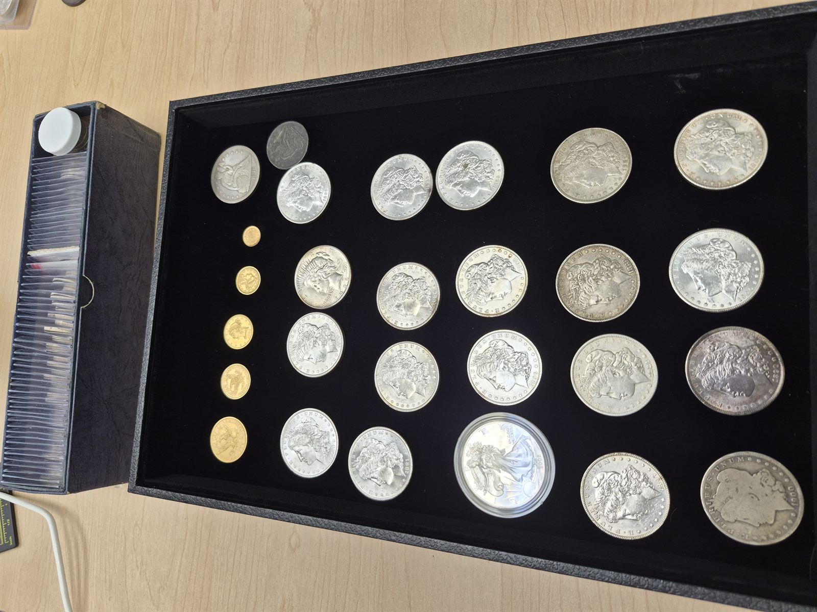 A display tray of Morgan silver dollars and small fractional gold coins evaluated at our office